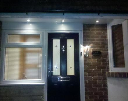 Low voltage spotlights illuminating a front door and access step. Outside lantern to the side of the front door