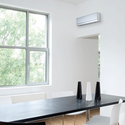 High Level Wall Mounted Air Conditioning Unit In A Residential Dining Room